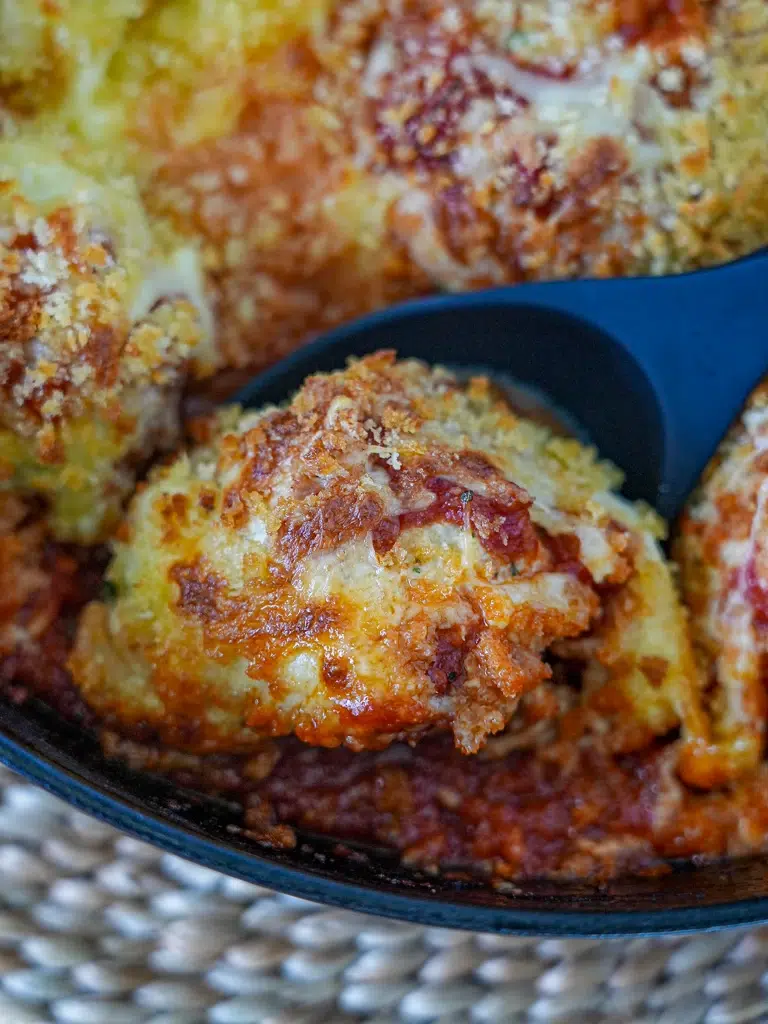 Close-up of a spoon scooping Chicken Meatball Parmigiana